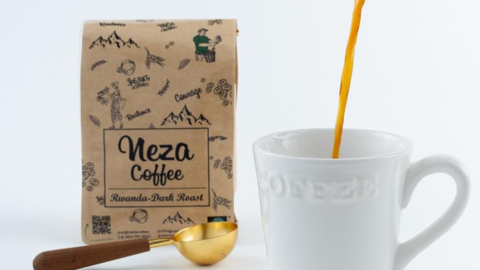 The image displays a close-up, eye-level shot on a clean white background, showcasing the process of pouring coffee. The main focus is on a white ceramic mug with the word "COFFEE" embossed on its side. A stream of dark brown coffee is being poured from a copper and glass French press, which is angled from the top right corner of the frame, with its lid slightly ajar and plunger mechanism visible. The coffee stream is a rich, dark amber color. 