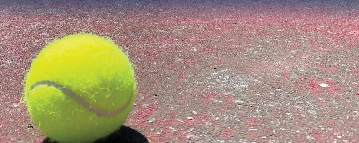 A close up of a tennis ball on a tennis court.