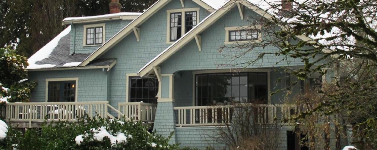 The exterior of the Rush House, including the snow covered shrubs in the front yard.
