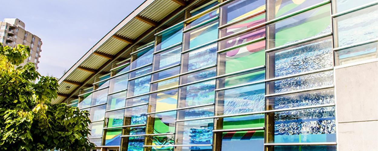 The exterior of the Aquatic Centre with brightly coloured glass decorating the wall.