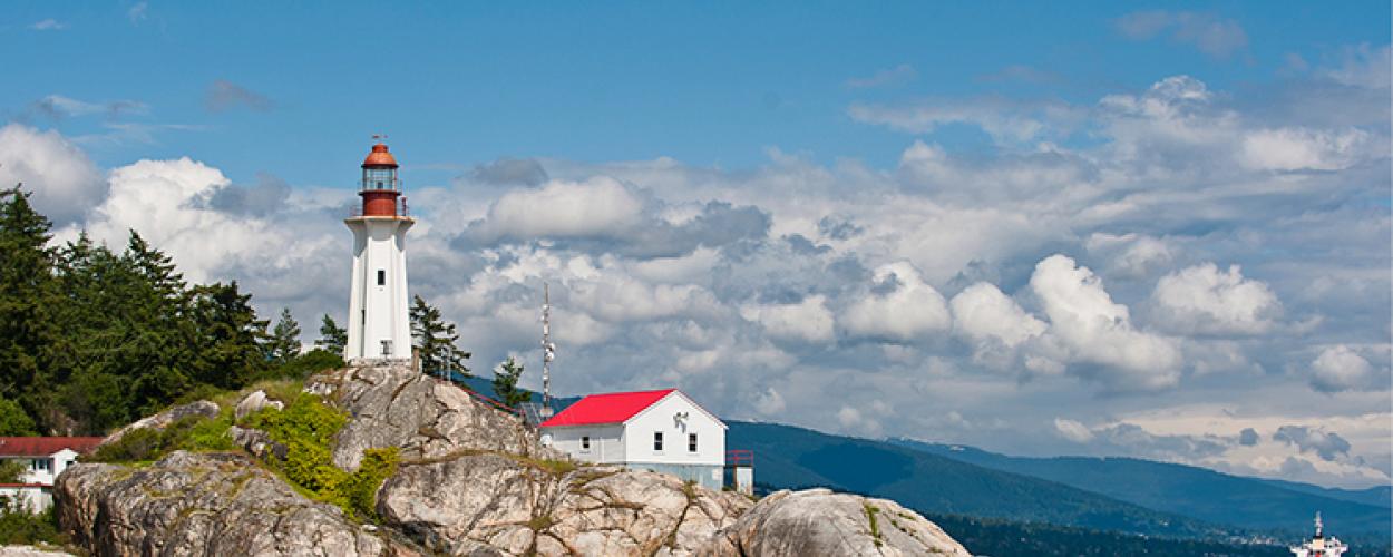 A lighthouse on a rocky stretch of shoreline.