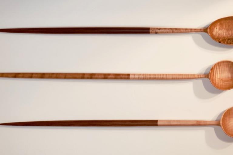 A group of chopsticks is placed on a white surface, showcasing their design and texture. The utensils are commonly used in various cuisines, indicating their role as essential kitchen tools. Overall, the image captures a simple yet elegant arrangement of these dining instruments in an indoor setting.