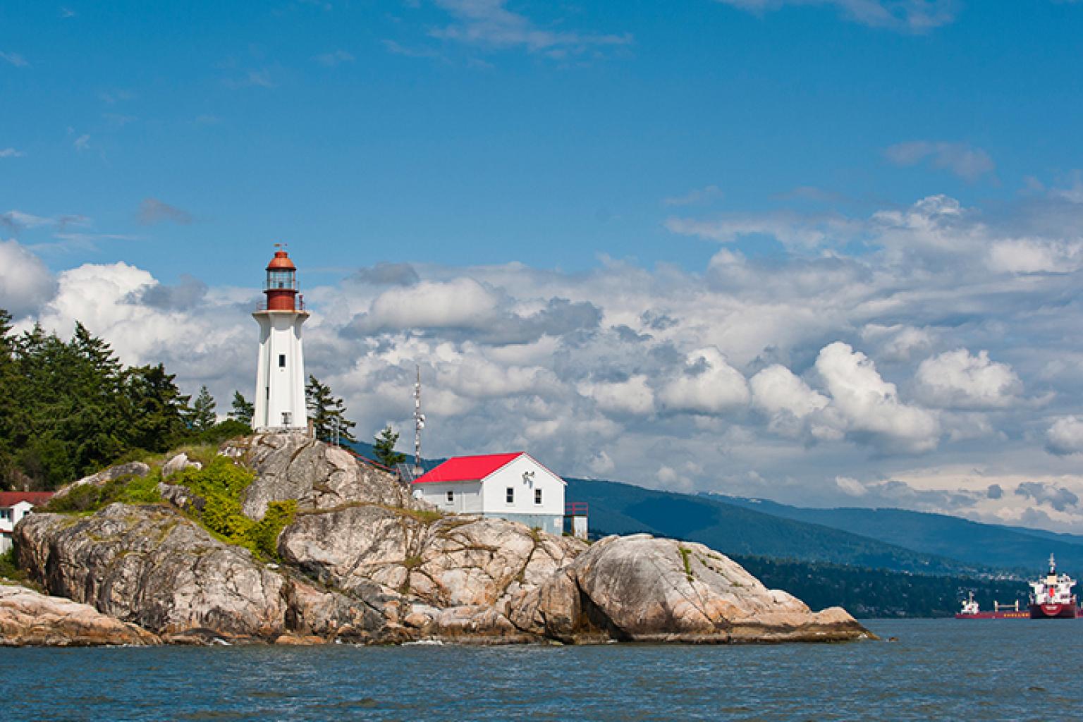 A lighthouse on a rocky stretch of shoreline.